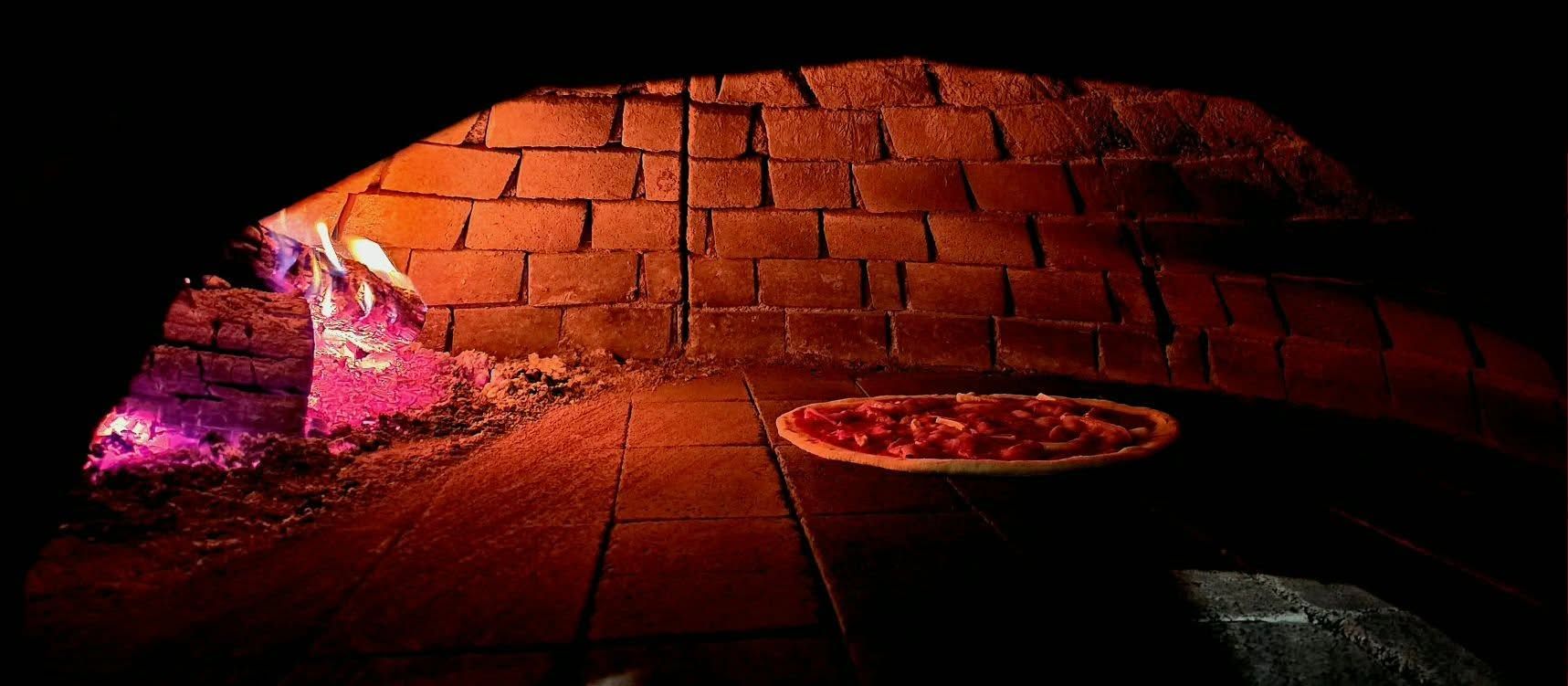 Pizza piecze się w rozgrzanym piecu opalanym drewnem